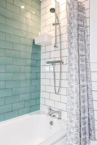 bagno con vasca e tenda doccia di Carlile House - London 5 bedroom Free Parking & Garden by Damask Homes a Londra