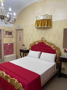 a bedroom with a bed with a red and gold headboard at B&B Sotto gli archi in Catania