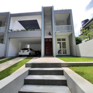 a house with a car parked in front of it at OESIS - Stylish Holiday Home in the heart of Galle in Galle