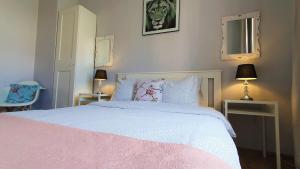 a bedroom with a pink bed with two tables and two lamps at Apartament Przy Starówce - Bella in Bolesławiec