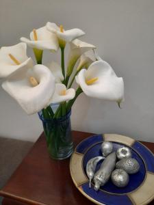 a vase of white flowers and a plate of silver balls at 64 on Malabor in Pretoria