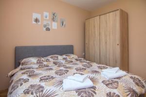 una camera da letto con un letto e asciugamani di Apartman Agin Kutak a Bajina Bašta