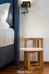 a nightstand next to a bed with a clock on it at AthensThea Beta Luxury Penthouse Apt in Omonia in Athens