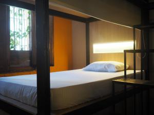 a bedroom with a bed and a window at Baboon Hostel in Santa Marta
