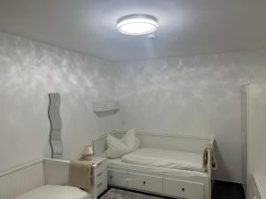 biały pokój z łóżkiem i lampą w obiekcie Bibis Ferienwohnung w Monachium
