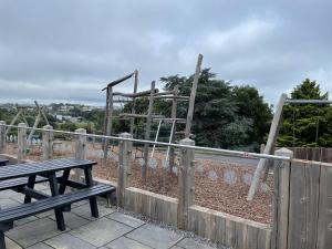 a wooden fence with a picnic table and swings at G10 Hoburne Devon Bay pet friendly in Goodrington