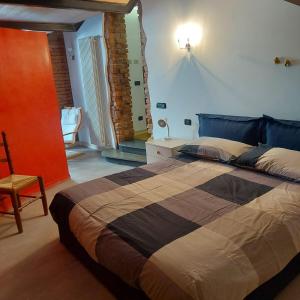 コルマーノにあるB&b La Corte di Brusuglioのベッドルーム(大型ベッド1台、椅子付)