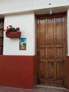 una puerta de madera con una maceta de flores en la pared en Pueblito viejo, tu casa por días o temporadas en Zapatoca