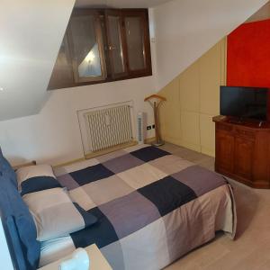 ein Schlafzimmer mit einem Bett und einem TV. in der Unterkunft B&b La Corte di Brusuglio in Cormano