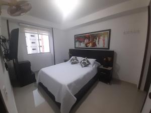 ein Schlafzimmer mit einem weißen Bett und einem Fenster in der Unterkunft Apartamento 402-G San Gil in San Gil