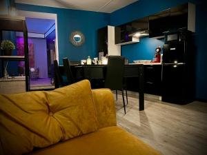 un salon avec un canapé jaune et une cuisine dans l'établissement Charmant logement avec Spa, Sauna et terrasse, à Bergues