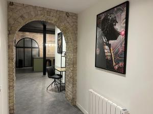 a hallway with an archway with a painting on a wall at Loft atypique Dunkerque Centre in Dunkerque