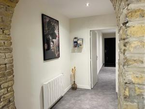 a hallway with white walls and a brick wall at Loft atypique Dunkerque Centre in Dunkerque