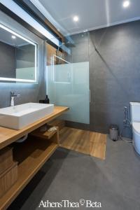 La salle de bains est pourvue d'un lavabo blanc et d'une douche. dans l'établissement AthensThea Luxury Penthouse Apt in Omonia 115sq.m., à Athènes