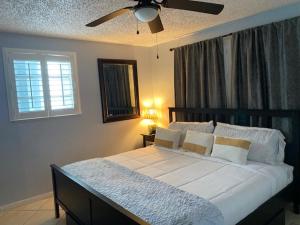 um quarto com uma cama grande e uma ventoinha de tecto em Modern 2/1 Apt near Midtown and Beaches em Miami