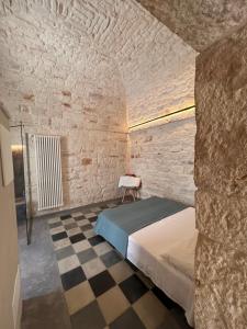 a bedroom with a bed and a checkered floor at Suite Annalisa in Ceglie Messapica