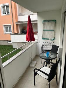 a balcony with a table and chairs and an umbrella at Bibis Ferienwohnung in Munich