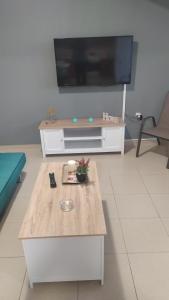 a living room with a coffee table and a flat screen tv at Mama Marina apartement near to the airport in Antimácheia