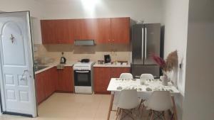 una cucina con tavolo, sedie e frigorifero di Mama Marina apartement near to the airport ad Antimácheia