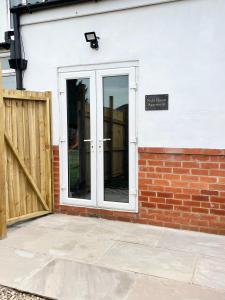a door with a sign on the side of a building at Nidd House Apartment in Harrogate