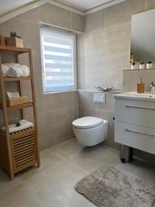 La salle de bains est pourvue de toilettes, d'un lavabo et d'une fenêtre. dans l'établissement Ferienwohnung LiDuJe, à Eislingen/Fils