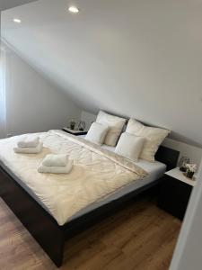 - un grand lit avec 2 serviettes blanches dans l'établissement Ferienwohnung LiDuJe, à Eislingen/Fils