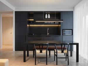 a black kitchen with a dining room table and chairs at Burbury Hotel in Canberra