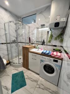a bathroom with a washing machine and a shower at Apartament Wilkońskiego in Inowrocław