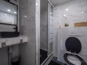 a bathroom with a toilet and a glass shower at Maison triplex 6 personnes près de Disney et Paris in Montévrain