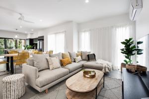 a living room with a couch and a table at Luxury Modern 4 BR Pet Friendly Family Beach Home in Yaroomba