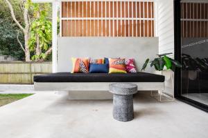 a bench with colorful pillows on a patio at Luxury Modern 4 BR Pet Friendly Family Beach Home in Yaroomba