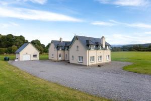 a large house sitting on top of a gravel driveway at Beallach Lodge in Culrain