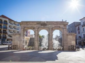 a stone arch with a fountain in a city at Appartement T2 45 M2 Meublé 3 étoiles tout confort hyper centre de Dax in Dax