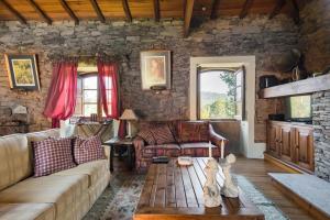 uma sala de estar com um sofá e uma mesa em R3 Service - Quinta da Melroa - Mountain Villa em Viseu