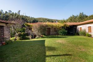 um quintal de uma casa com um jardim de relva em R3 Service - Quinta da Melroa - Mountain Villa em Viseu