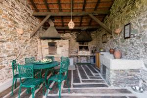 um pátio com uma mesa e cadeiras e uma cozinha em R3 Service - Quinta da Melroa - Mountain Villa em Viseu