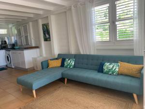 - un canapé bleu dans le salon dans l'établissement Héritage créole 1, à Sainte-Luce