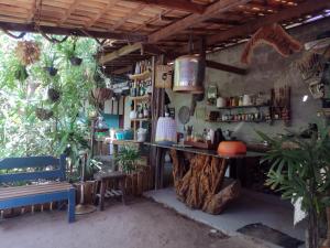 a kitchen with a counter and a table and some plants at Hospedaria Recanto da Paz in Itaporanga dʼAjuda
