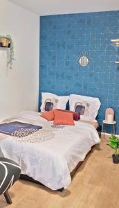 a bedroom with a large bed with a blue wall at Cosy Appart Hotel Boulogne -Paris in Boulogne-Billancourt