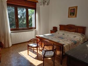 een slaapkamer met een bed met 2 stoelen en een tafel bij Appartamento doppi bagni sei posti letto in Viverone