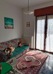 een woonkamer met een groene bank met een knuffeldier bij Appartamento doppi bagni sei posti letto in Viverone