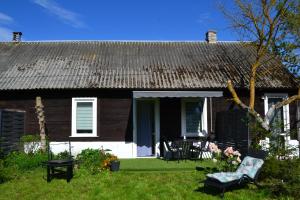 una piccola casa con una veranda verde e una sedia di Agroturystyka Staw i koza a Rzewnie