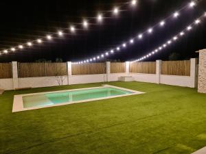un patio trasero con una piscina con luces. en Casa Rural Kentia, en Valdepeñas