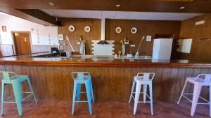 un bar con tres taburetes azules y blancos en Casa Rural Kentia, en Valdepeñas