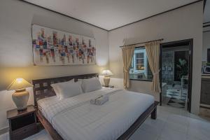 ein Schlafzimmer mit einem großen weißen Bett und einem Fenster in der Unterkunft Panorama Cottages I in Legian + 89 Fotos