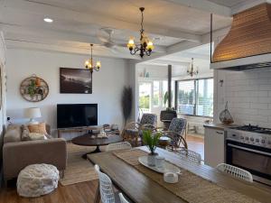 a kitchen and living room with a table and chairs at A Drop In The Ocean by Kingscliff Accommodation in Kingscliff