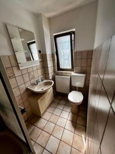 a bathroom with a toilet and a sink and a mirror at Praktisches Zimmer im Großen Haus mit garten in Düsseldorf