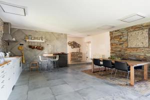 uma cozinha com uma mesa e cadeiras e uma parede de pedra em R3 Service - Casula no Caramulo em Tondela