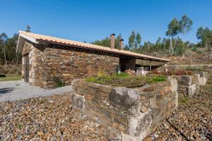 une maison en pierre avec un mur en pierre et un bâtiment dans l'établissement R3 Service - Casula no Caramulo, à Tondela