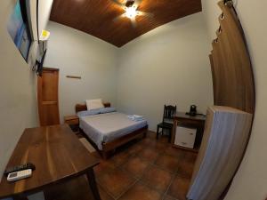 a small room with a bed and a table at Laureles Collection Uvita - Cabinas Los Laureles in Uvita